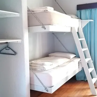 a bunk bed room with white bunk beds at Aloha Lodge in Cape Town