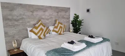 a white bed with pillows and towels on it at Matt's Place in Cape Town