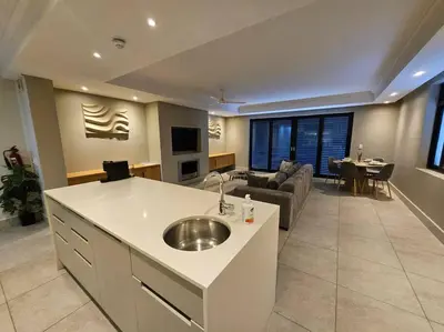 a kitchen and living room with a sink and a couch at Central - Whale Watching Paradise -Self check in in Hermanus