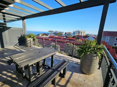 a wooden bench sitting on top of a balcony at Central - Whale Watching Paradise -Self check in in Hermanus