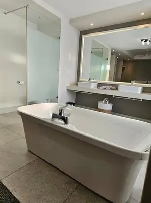a large bathroom with a sink and a mirror at Central - Whale Watching Paradise -Self check in in Hermanus