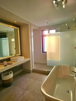 a bathroom with a tub and a sink and a mirror at Central - Whale Watching Paradise -Self check in in Hermanus