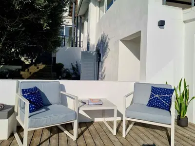 two chairs and a table on a patio at 'Kaya Moya' - Luxury Suite for 2 with Ocean Views in Gordonʼs Bay