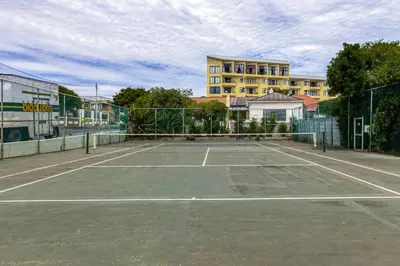a tennis court in front of a building at Elegance on Beach in Cape Town