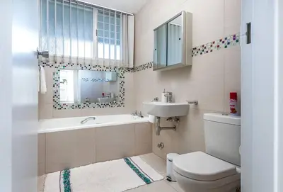 a bathroom with a toilet and a sink and a mirror at Elegance on Beach in Cape Town