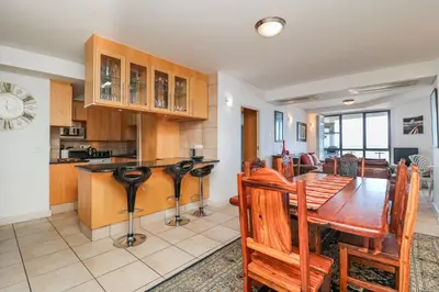 a kitchen and dining room with a wooden table and chairs at 506 Hibernian Towers Luxury Self Catering Apartment Strand Cape Town South Africa in Cape Town