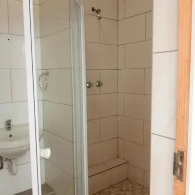 a bathroom with a shower and a sink at Sunshine Guest House in Cape Town