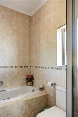 a bathroom with a tub and a toilet at Devon View Olive Farm in Stellenbosch