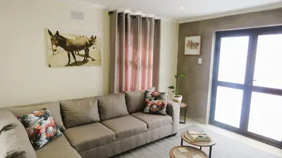 a living room with a couch and a horse picture on the wall at Sonvanger 3 in Paarl