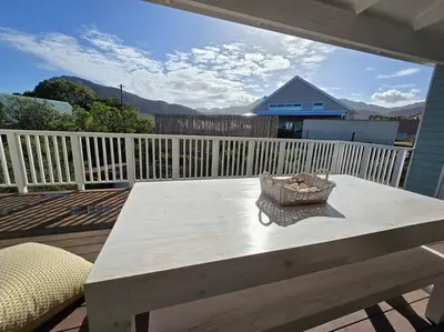 a picnic table on the deck of a house at Fijnbos in Pringle Bay