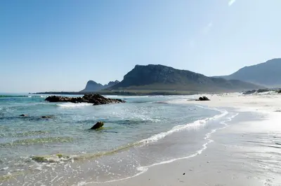 a sandy beach with rocks in the water at Fijnbos in Pringle Bay