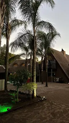 a group of palm trees in front of a building at STAY In TEHAMA in Cape Town