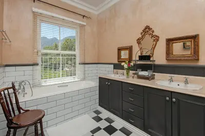 a bathroom with a tub and a sink and a bath tubermott at Franschhoek villa in Franschhoek