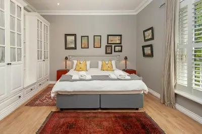 a bedroom with a large bed with yellow pillows at Franschhoek villa in Franschhoek