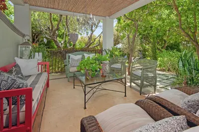 a patio with couches and a table and trees at Franschhoek villa in Franschhoek