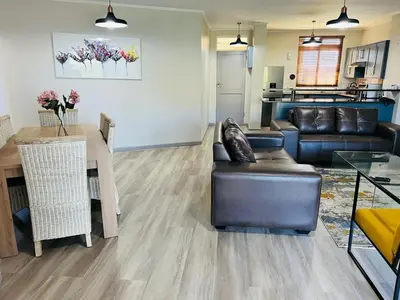 a living room with a couch and a table at 204 Island Club Luxury Apartment - Cape Town in Cape Town