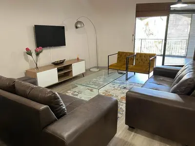 a living room with two couches and a flat screen tv at 204 Island Club Luxury Apartment - Cape Town in Cape Town