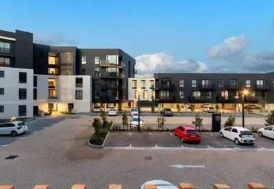 a parking lot with cars parked in front of buildings at Zals Luxury -Nine Palms in Cape Town