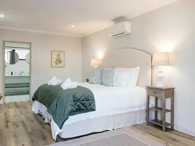 a bedroom with a white bed with a green blanket at Yonder Hill Accommodation in Raithby