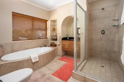 a large bathroom with a tub and a shower at Ocean View living in Hermanus