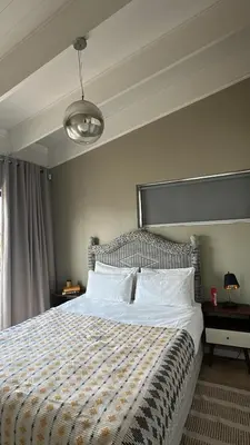 a bedroom with a large bed with a striped blanket at Central Retreat Cozy Apartment Near Attractions in Cape Town