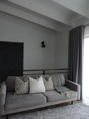 a living room with a gray couch with pillows at Central Retreat Cozy Apartment Near Attractions in Cape Town