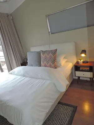 a white bed in a room with a window at Central Retreat Cozy Apartment Near Attractions in Cape Town