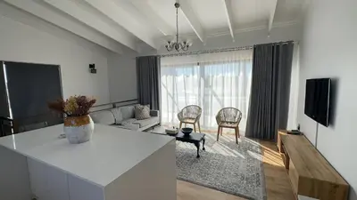 a white living room with a table and two chairs at Central Retreat Cozy Apartment Near Attractions in Cape Town