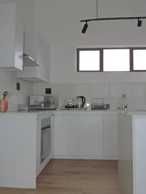 a white kitchen with white cabinets and appliances at Central Retreat Cozy Apartment Near Attractions in Cape Town