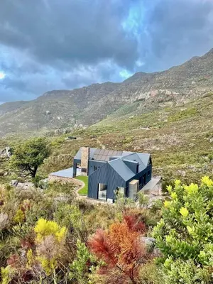 a house in a field with mountains in the background at The Unbound - Escape the Ordinary in Romansrivier