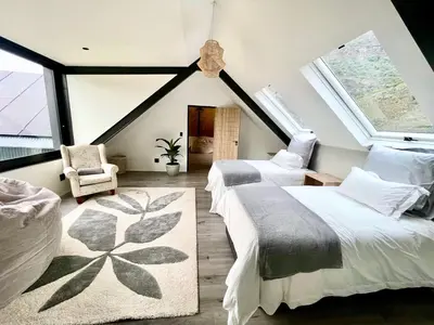 a attic bedroom with two beds and a window at The Unbound - Escape the Ordinary in Romansrivier