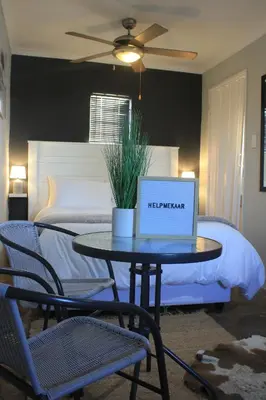 a laptop on a table in front of a bed at Helpmekaar in Wellington