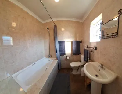 a bathroom with a tub and a toilet and a sink at Helpmekaar in Wellington