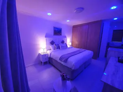 a bedroom with a large bed with purple lighting at Serena inn Room 1 in Cape Town
