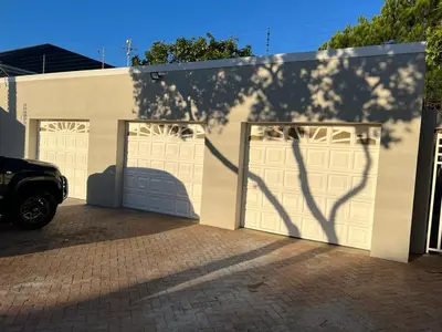 a shadow of a tree on a white garage door at Serena inn Room 1 in Cape Town