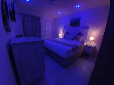 a purple bedroom with a bed and a sink at Serena inn Room 1 in Cape Town