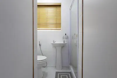 a white bathroom with a toilet and a sink at Serena inn Room 1 in Cape Town