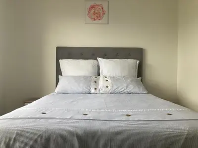a bed with white sheets and pillows in a bedroom at Smartstay Apartments The Sandown in Cape Town