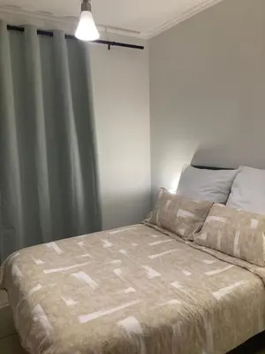 a bed in a bedroom next to a window at Smartstay Apartments The Sandown in Cape Town