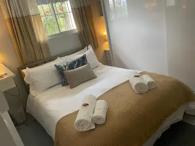 a bedroom with a bed with towels on it at Lente Beach Cottage, Fleur Park, Gordon's Bay in Gordonʼs Bay