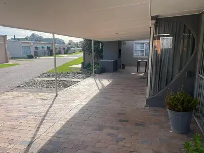 a patio with a white tent and a sidewalk at Lente Beach Cottage, Fleur Park, Gordon's Bay in Gordonʼs Bay