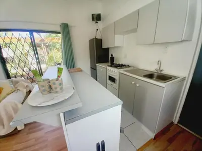a white kitchen with a sink and a counter top at The Haven Hide-Away in Fisherhaven