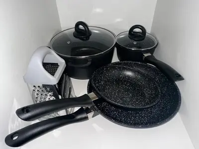 a black frying pan and two pots in a drawer at Sleek Modern Luxury Pool Side Apartment in Cape Town