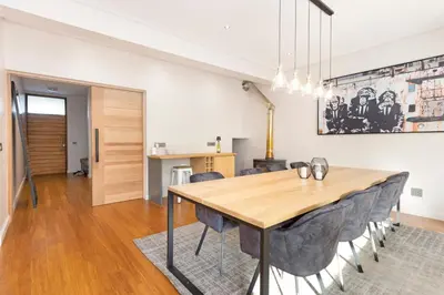 a dining room with a wooden table and chairs at Sunset Serenity Villa in Cape Town