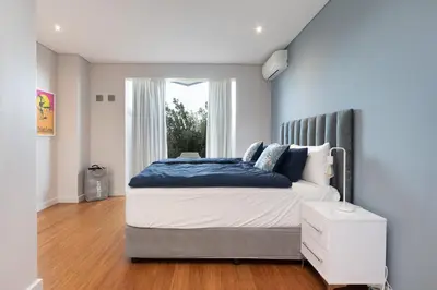 a bedroom with a large bed with a window at Sunset Serenity Villa in Cape Town