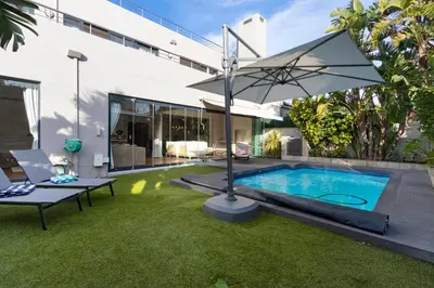 a backyard with a swimming pool and an umbrella at Sunset Serenity Villa in Cape Town