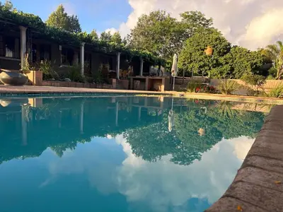 a swimming pool with blue water in front of a building at The Villa at Marnas Private Self-Catering Accommodation in Cape Town