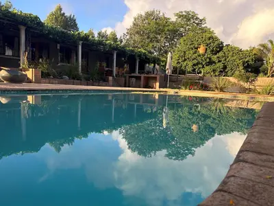 a swimming pool with blue water in front of a building at The Villa at Marnas Private Self-Catering Accommodation in Cape Town