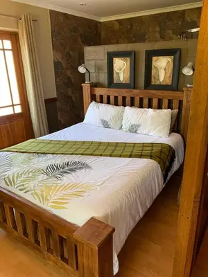 a bedroom with a large bed with a wooden frame at Marnas Private Self Catering Accommodation The Cottage in Cape Town
