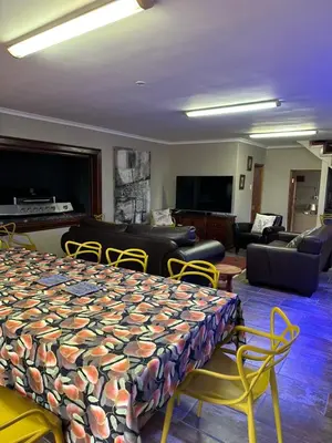 a room with a bed and chairs and a living room at Marnas Private Self Catering Accommodation The Cottage in Cape Town